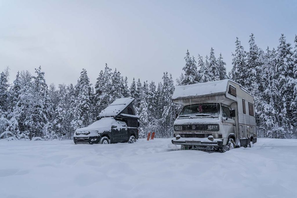 Zwei Campingfahrzeuge im Schnee