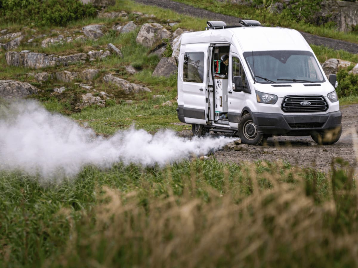 Weißer Camper mit deutlicher weißer Qualmbildung unter dem Fahrzeug aus dem Auspuff der Standheizung